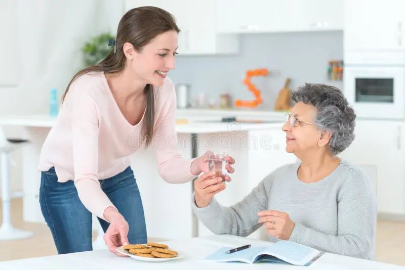 woman-serving-old-women-water-woman-serving-old-woman-water-103101093